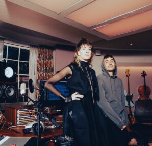 Dan with a camera next to large wall of rocks