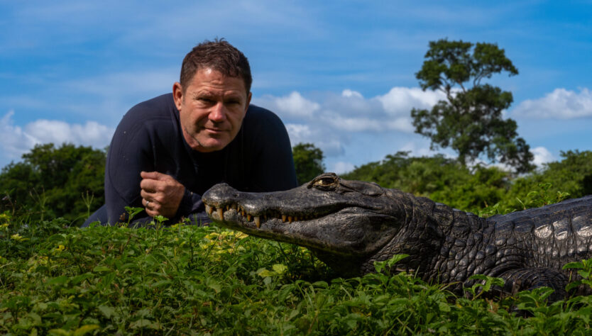 Steve Backshall laying next to a crocodile